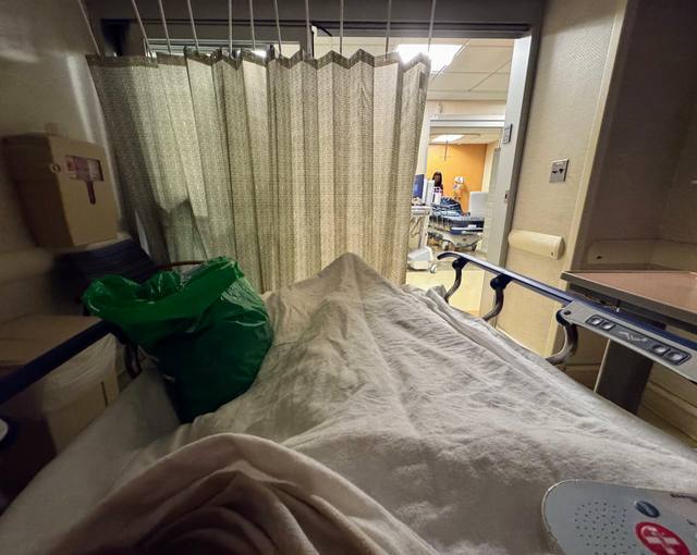View from a hospital bed toward a curtained doorway
