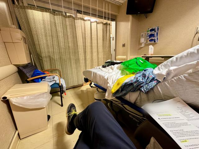 Recovery room with clothes on the bed and discharge papers in the foreground